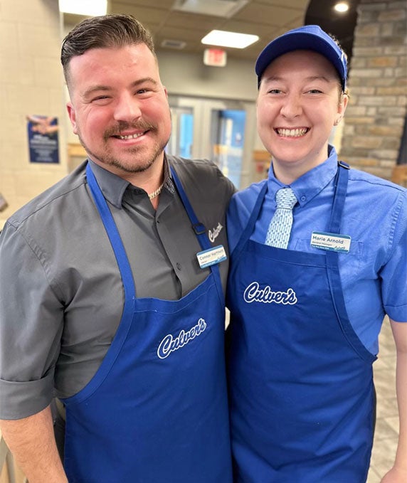 Marie and fellow crew member stand together and smile.